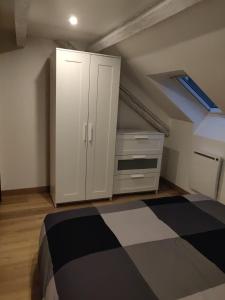 a bedroom with a white cabinet and a bed at Le business, duplex moderne special PRO de passage in Sarreguemines