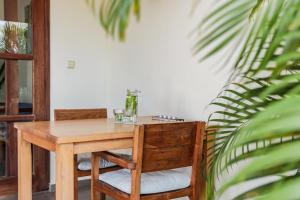 een houten tafel en stoelen in een kamer met een plant bij ABC Resort Curacao in Willemstad