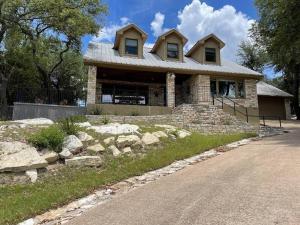a stone house with a roof on the side of a road at Lakeview Bungalow-Access to Lake, Pool, Gym, &Park in Lago Vista
