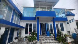 a blue and white building with stairs and plants at Hotel spa la buena vida in Fusagasuga