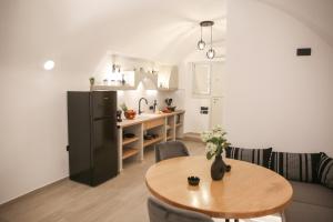 a living room with a table and a kitchen at Luxury Canava in Emporio