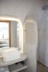 Baño blanco con lavabo y espejo en Luxury Canava en Emporio Santorini