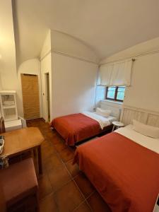 a room with two beds and a table and a desk at Pension u Sv. Prokopa in Středokluky