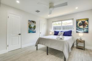 a bedroom with a bed with blue pillows and a window at Fort Lauderdale Vacation Rental about 8 Mi to Beaches! in Fort Lauderdale