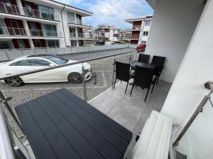 un balcone con tavolo, sedie e auto di Apartament KLIFOWA REWAL przy plaży a Rewal