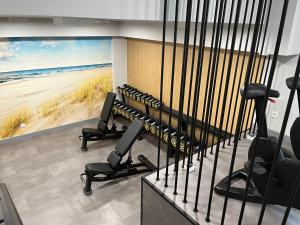 a gym with a large painting of the beach at Apartament KLIFOWA REWAL przy plaży in Rewal