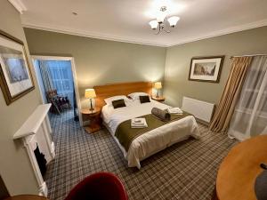 Habitación de hotel con cama y chimenea en Birches Brow Boutique Guest Rooms en Aughton