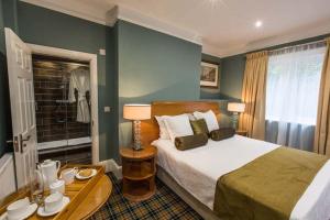 a bedroom with a bed and a table with two lamps at Birches Brow Boutique Guest Rooms in Aughton