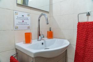 Casarella Chiara في نابولي: حمام مع حوض ومنشفة حمراء