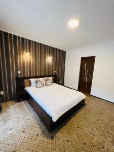 una camera da letto con un grande letto con lenzuola bianche di Pensiunea Zimbrul a Poiana Brasov