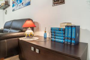 einen Tisch mit einer Lampe und Büchern darauf in der Unterkunft Casarella Chiara in Neapel