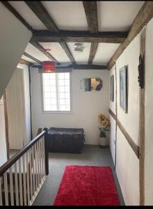 a hallway with a red rug and a bed in a room at The Cottage with free parking in Hastings