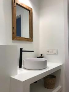 a white bathroom with a sink and a mirror at Los Palmitos in Agua Amarga