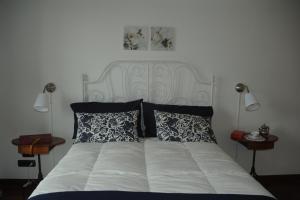 1 cama blanca con 2 mesas y 2 lámparas en Apartment Oltremarestudios, en Nápoles