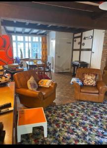 uma sala de estar com dois sofás de couro e uma mesa em The Cottage with free parking em Hastings