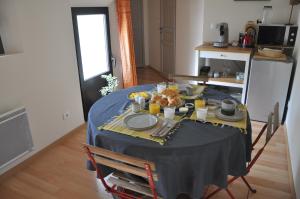 a table with a blue table cloth and food on it at La Ferme de Vrilly in Reims