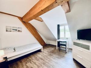 Habitación con cama, TV y escritorio. en Monteurzimmer ZIMMERzuVERMIETEN in Flumenthal Solothurn, en Attiswil