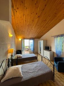 a bedroom with two beds and a wooden ceiling at Residence VILLA MOROSI - Favone in Conca