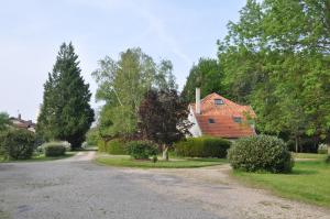 eine Feldstraße, die zu einem Holzhaus führt in der Unterkunft La Ferme de Vrilly in Reims