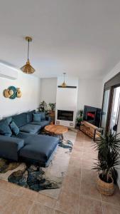 een woonkamer met een blauwe bank en een tafel bij Casa Christiana, Lardos in Lardos
