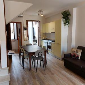 Il comprend un salon avec une table et des chaises ainsi qu'une cuisine. dans l'établissement Matteotti House, à Bardolino
