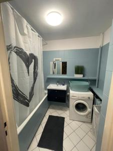 a bathroom with a sink and a washing machine at Pokoje do wynajęcia - Podwisłocze 8a in Rzeszów