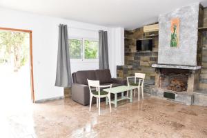 a living room with a couch and chairs and a fireplace at Barreira Beachfront Room 1 in Verga Kalamata