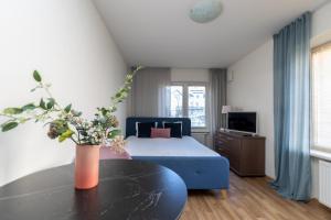 Un dormitorio con una cama azul y una mesa en Mare Apartments, en Palanga