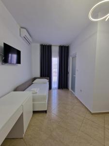 um quarto branco com uma cama e um sofá em Vila Klari em Ksamil