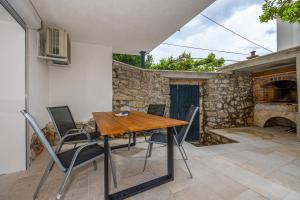 - une table et des chaises sur une terrasse avec une cheminée en pierre dans l'établissement Villa Rocca, à Crikvenica