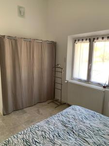 1 dormitorio con cama, cortinas y ventana en Terre de Lumière, en Nyons