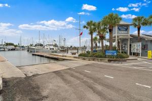 Un puerto deportivo con barcos y palmeras y un edificio. en Quaint Gulfport Beach Bungalow, en San Petersburgo