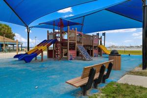 un parque con parque infantil con tobogán y columpios en Quaint Gulfport Beach Bungalow, en San Petersburgo