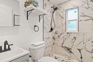 un baño con inodoro y lavabo en Quaint Gulfport Beach Bungalow, en San Petersburgo 40 fotos más