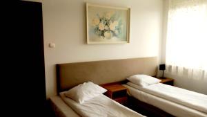 Pokój z dwoma łóżkami i zdjęciem na ścianie w obiekcie Hotel i Restauracja 13 Smaków w mieście Częstochowa