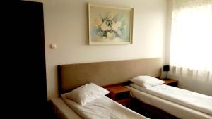 a room with two beds and a picture on the wall at Hotel i Restauracja 13 Smaków in Częstochowa +48 photos