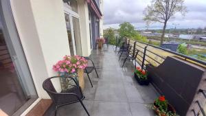 uma varanda com cadeiras e flores num edifício em Hotel i Restauracja 13 Smaków em Czestochowa