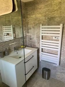 ein Badezimmer mit einem weißen Waschbecken und einem Spiegel in der Unterkunft Terre de Lumière in Nyons