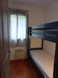 1 dormitorio con litera y ventana en Mazet Provençal dans Village Vacances, en Gaujac