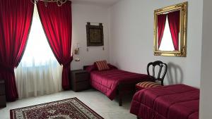 a room with two beds and a mirror and red curtains at Varapodio B&B in Varapodio