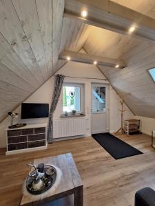 een grote woonkamer met een gewelfd plafond en een tv bij Ferienwohnung Krähling in Schmallenberg