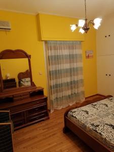 a bedroom with a mirror and a bed and a dresser at Дом для гостей in Athens