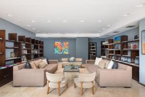 a living room with couches and chairs and shelves at Sofitel La Reserva Cardales in Río Luján