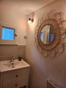 uma casa de banho com um lavatório e um espelho na parede em Le Clos Loret em Saint-Germain-du-Corbéis