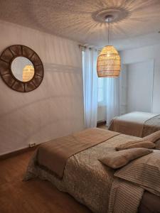 um quarto com 2 camas e um espelho na parede em Le Clos Loret em Saint-Germain-du-Corbéis