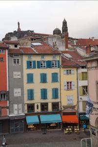 um grupo de edifícios com janelas coloridas e telhados em Agapi em Le Puy-en-Velay