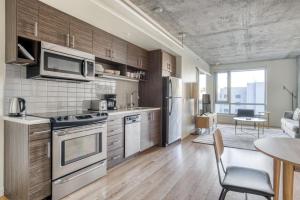 eine Küche mit Küchengeräten aus Edelstahl und ein Wohnzimmer in der Unterkunft Lower Nob Hill 1BR w Gym Lounge WD CVS onsite SFO-788 in San Francisco