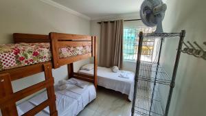 a bedroom with two bunk beds and a fan at Casa confortável e segura na região da Pampulha in Belo Horizonte