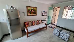 ein Wohnzimmer mit einem Sofa und einem Kühlschrank in der Unterkunft Casa confortável e segura na região da Pampulha in Belo Horizonte