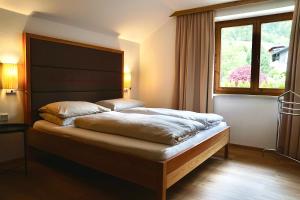een slaapkamer met een bed en een groot raam bij Landhaus Pölzl in Bodensdorf